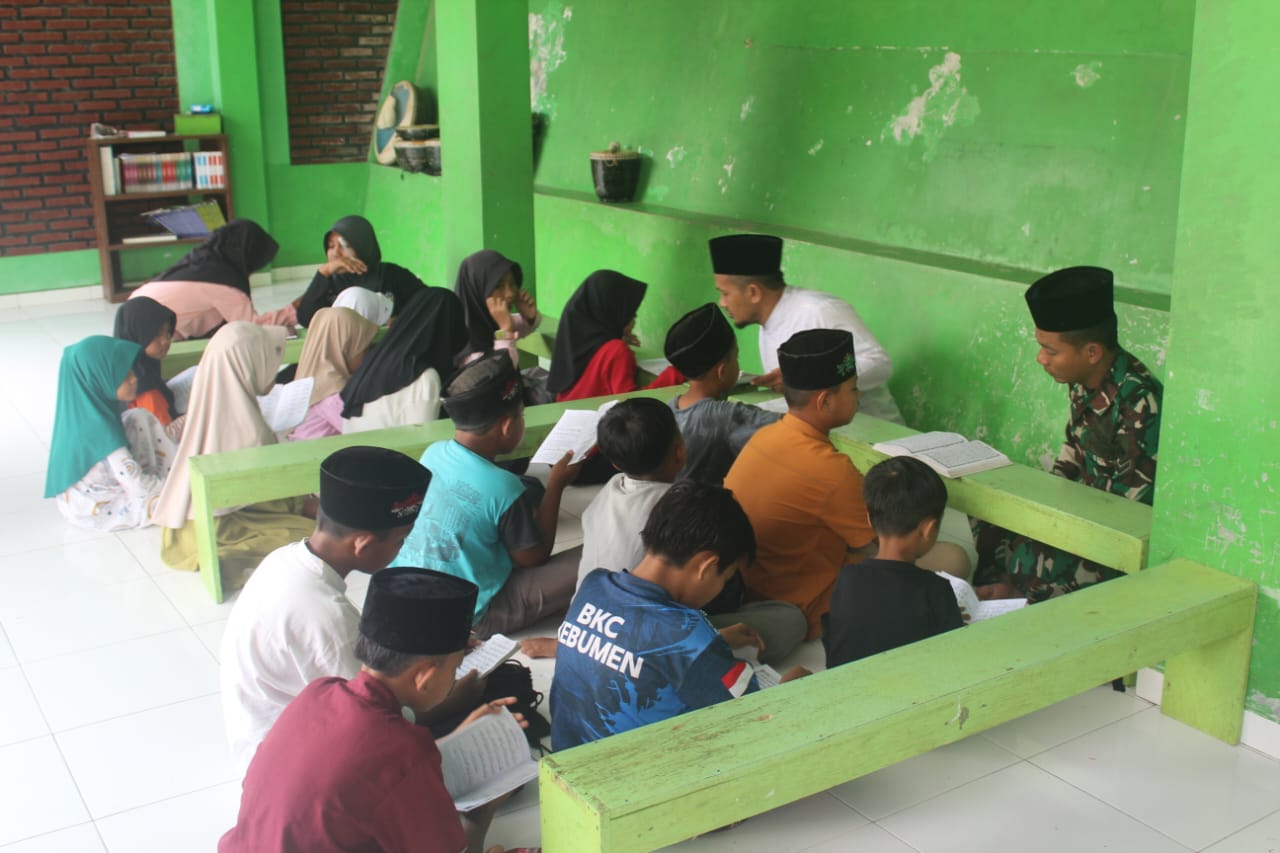 Di Serambi TPQ, Prajurit TNI Duduk Mengajarkan Huruf Hijaiyah